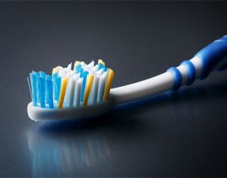 Close-up of a toothbrush with blue, white, and yellow bristles