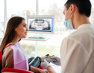 A dentist discusses the possibility of dental implants with a woman in Coral Springs