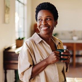 Smiling woman enjoying coffee at home