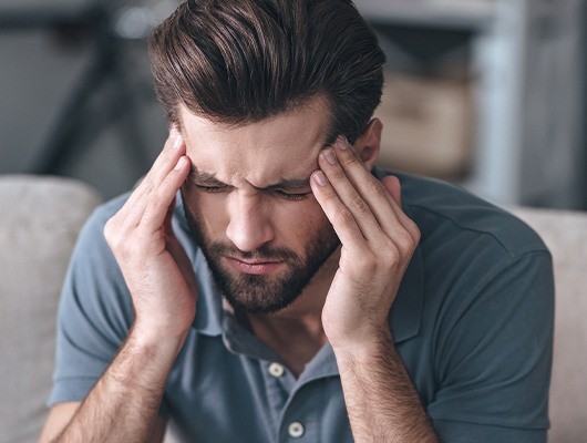 handsome man holding head with fingers