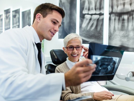 patient and dentist reviewing X-ray for dental implant procedure Coral Springs