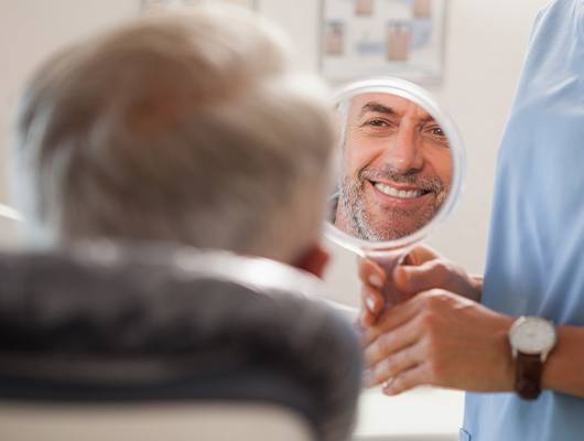 man's face smiling in circle mirror