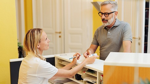  A man paying for dental treatment