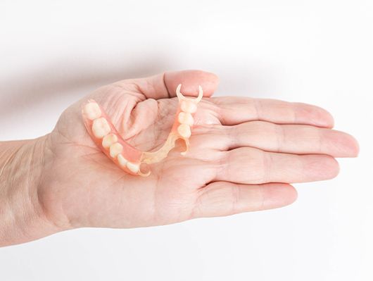 hand holding partial denture