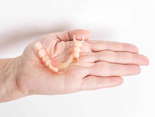 hand holding partial denture