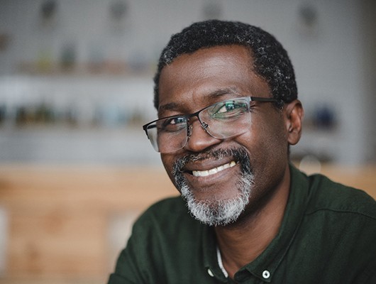 a man smiling after receiving new dentures