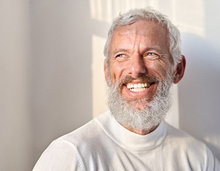 a man smiling with his new dentures 