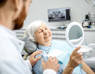 Older woman looking in dental mirror
