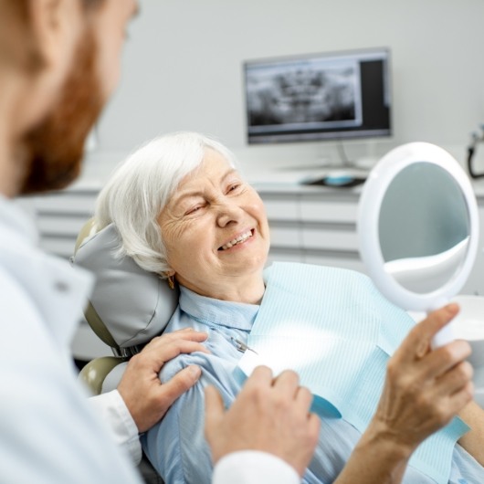 woman smiling into mirror