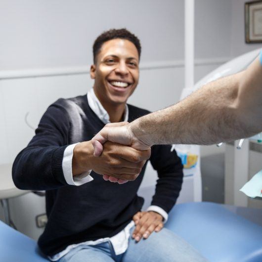 male patient shaking dentist hand