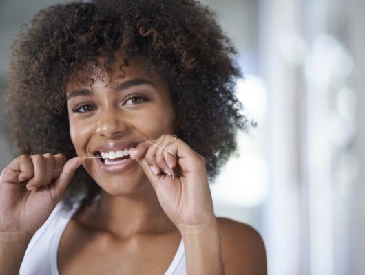 woman holding cheek speaking with dentist