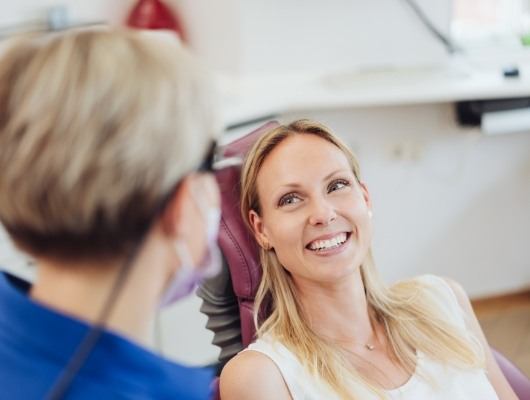 man in yellow smiling up at dentist