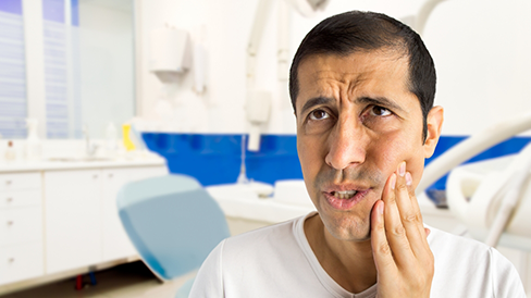 Man holding his cheek in pain at the dental office
