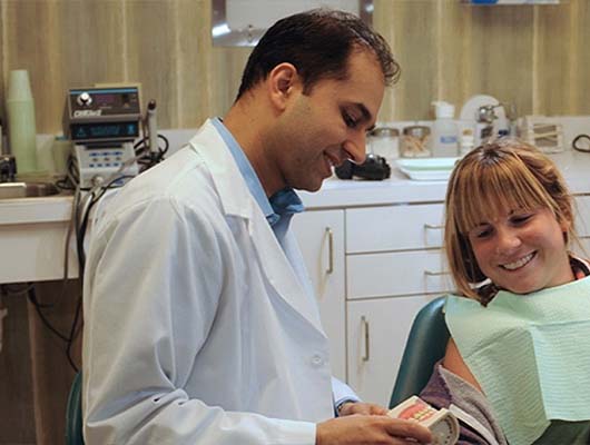 dentist showing a dental implant to a patient