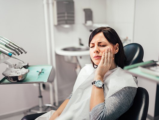 Woman with toothache at dentist's office 