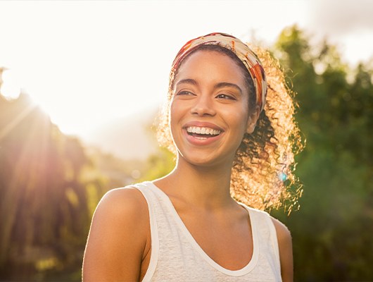 woman smiling with sun beaming down