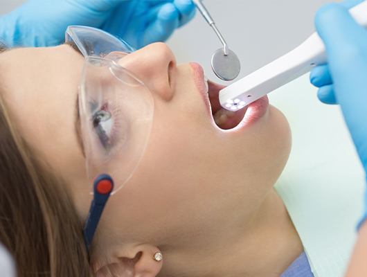 dentist using intraoral camera in womans mouth