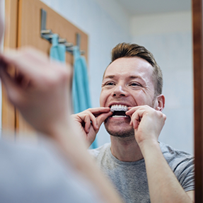 Man using a take home teeth whitening tray