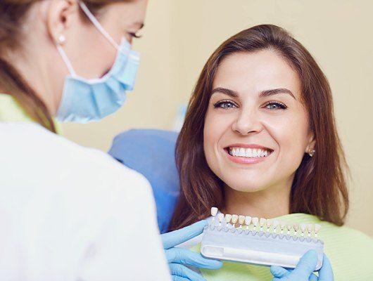 woman smiling at camera with shade chart