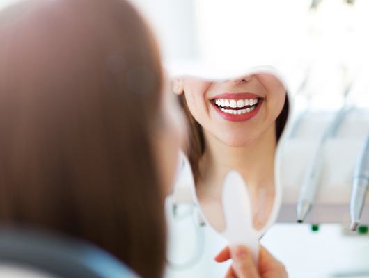 woman's smile in tooth mirror