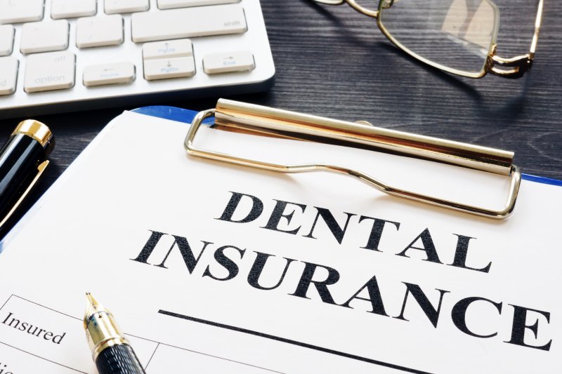 A dental insurance form on a black desk