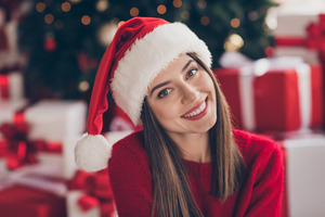 Woman in Santa hat sitting and smiling