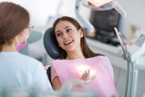 a patient smiling while visiting their dentist 