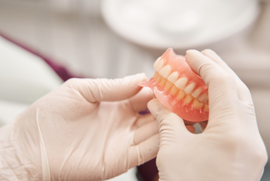 Dentist holding dentures